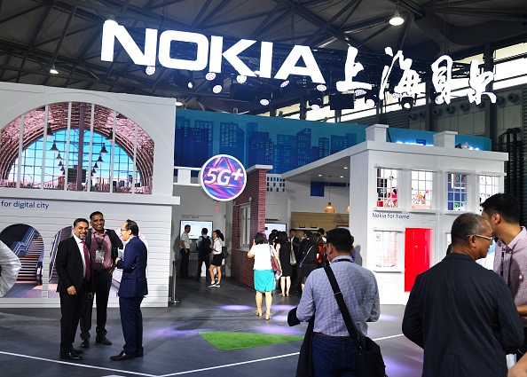 This photo taken on June 27, 2018 shows people gathering at a Nokia booth during the Mobile World Conference in Shanghai. (Photo by - / AFP) / China OUT (Photo credit should read -/AFP/Getty Images)
