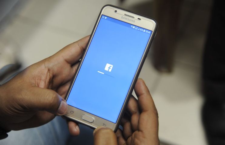 An Indian man poses for a photograph using Facebook on his cellpohne in Siliguri on March 27, 2018. India's ruling and main opposition parties on March 26 accused each other of using social media dirty tricks to mine and share followers' personal data. Prime Minister Narendra Modi's Bharatiya Janata Party (BJP) and the Congress party of Rahul Gandhi have seized upon the data breach storm surrounding Facebook and other media to score political points against one another. / AFP PHOTO / DIPTENDU DUTTA (Photo credit should read DIPTENDU DUTTA/AFP/Getty Images)
