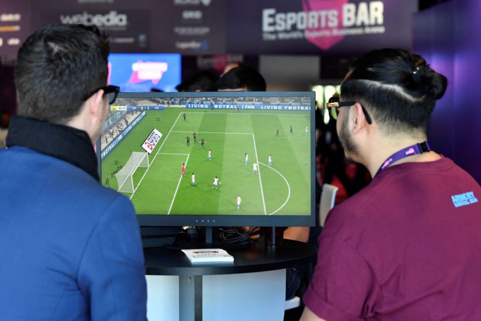 Visitors plays on EA Vancouver video game developer's football simulation video game FIFA 19 at the eSports Bar trade fair in Cannes, southern France on February 13, 2019. - After several years of development under radars, eSports is attracting more and more major brands that are betting on this sector in "structuring phase" to communicate with a different but committed target, according to Stephane Gambetta, director of activities and strategy at Reed Midem, the organizer of the eSports Bar trade fair in Cannes. (Photo by YANN COATSALIOU / AFP) (Photo credit should read YANN COATSALIOU/AFP/Getty Images)