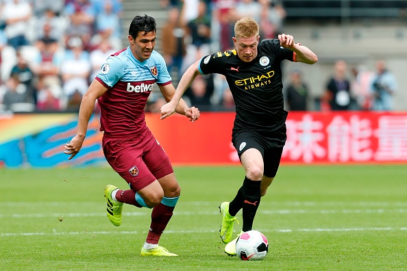 West Ham United's Paraguayan defender Fabi&aacute;n Balbuena (L) chases Manchester City's Belgian midfielder Kevin De Bruyne (R) during the English Premier League football match between West Ham United and Manchester City at The London Stadium, in east London on August 10, 2019. (Photo by Ian KINGTON / AFP) / RESTRICTED TO EDITORIAL USE. No use with unauthorized audio, video, data, fixture lists, club/league logos or 'live' services. Online in-match use limited to 120 images. An additional 40 images may be used in extra time. No video emulation. Social media in-match use limited to 120 images. An additional 40 images may be used in extra time. No use in betting publications, games or single club/league/player publications. /         (Photo credit should read IAN KINGTON/AFP/Getty Images)