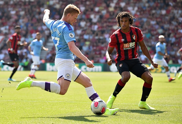 Manchester City's Belgian midfielder Kevin De Bruyne (L) crosses the ball past Bournemouth's Dutch defender Nathan Ake during the English Premier League football match between Bournemouth and Manchester City at the Vitality Stadium in Bournemouth, southern England on August 25, 2019. (Photo by Glyn KIRK / AFP) / RESTRICTED TO EDITORIAL USE. No use with unauthorized audio, video, data, fixture lists, club/league logos or 'live' services. Online in-match use limited to 120 images. An additional 40 images may be used in extra time. No video emulation. Social media in-match use limited to 120 images. An additional 40 images may be used in extra time. No use in betting publications, games or single club/league/player publications. /         (Photo credit should read GLYN KIRK/AFP/Getty Images)