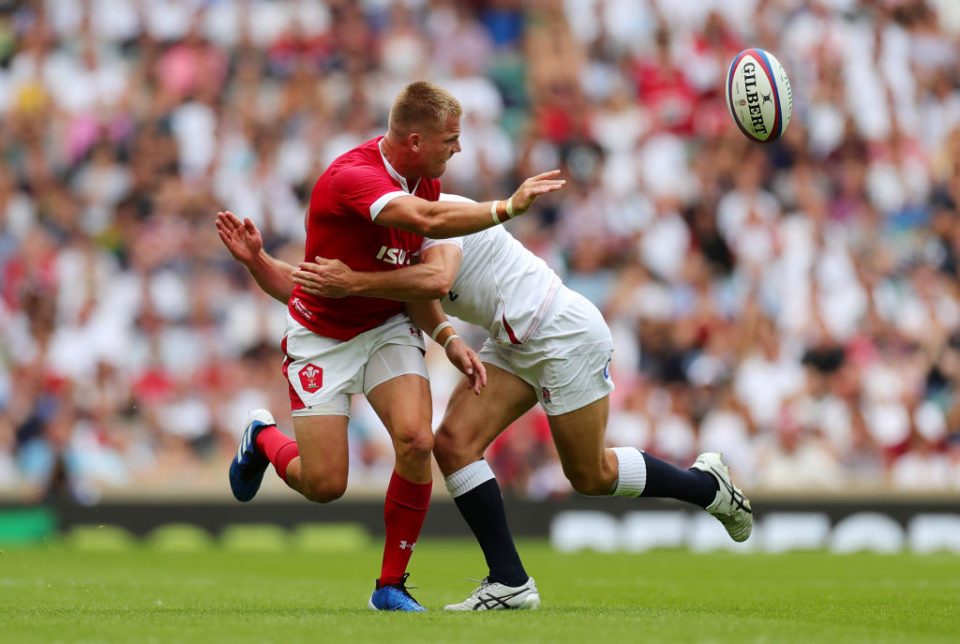 LONDON, ENGLAND - AUGUST 11: Gareth Anscombe of Wales offloads under pressure from Willi Heinz of England during the 2019 Quilter International match between England and Wales at Twickenham Stadium on August 11, 2019 in London, England. (Photo by Dan Mullan/Getty Images)
