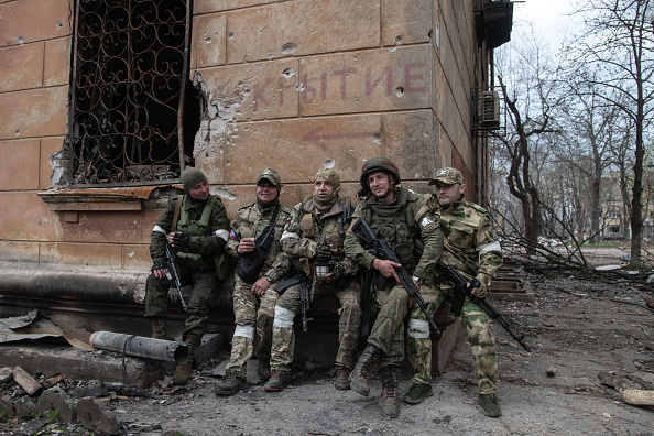Russian fighters rest behind a building some 500m from