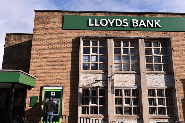 A man is seen withdrawing cash from outside Lloyds Bank . (Photo by Nathan Stirk/Getty Images)