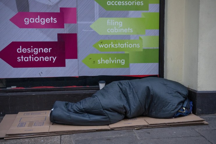 A homeless person sleeps in the street (Photo by Carl Court/Getty Images)