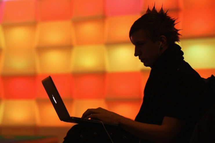 BERLIN, GERMANY - DECEMBER 28: A participant sits with a laptop computer as he attends the annual Chaos Communication Congress of the Chaos Computer Club at the Berlin Congress Center on December 28, 2010 in Berlin, Germany. The Chaos Computer Club is Europe's biggest network of computer hackers and its annual congress draws up to 3,000 participants. (Photo by Sean Gallup/Getty Images)
