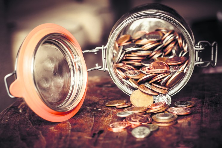 Jar filled with coins symbolizing cautious saving habits of older Brits avoiding stock market investments for retirement s...