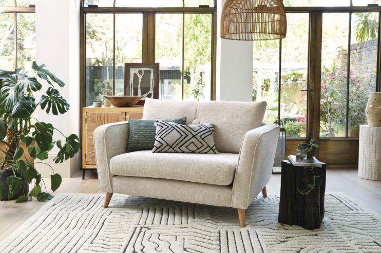 DFS Carlisle Chenille Cuddler sofa in showroom, showcasing furniture amid increased profits despite lower footfall.