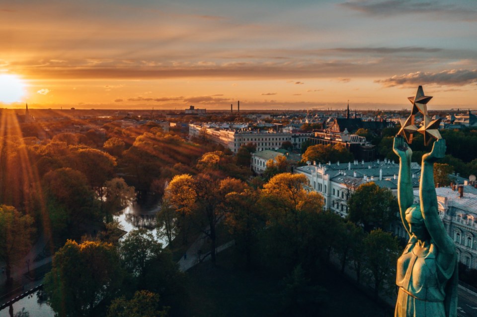 Scenic skyline of Riga with historic architecture and modern buildings under a clear blue sky, showcasing the citys vibran...