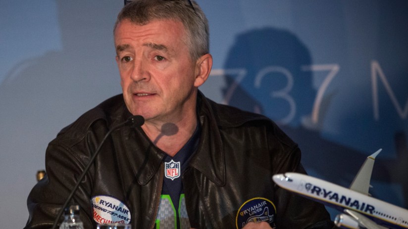 Michael OLeary speaking at a Ryanair press conference, dressed in a suit, discussing the airlines latest business updates