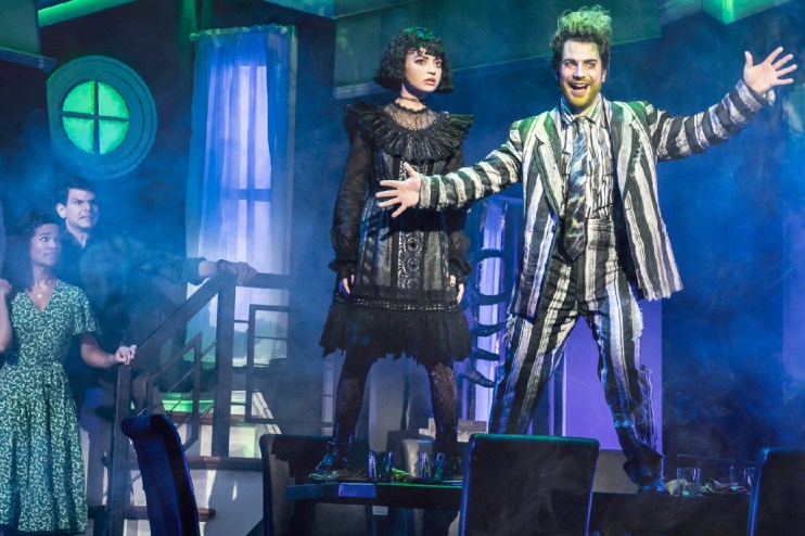 Beetlejuice-themed event showcasing iconic costumes and vibrant decorations at a popular entertainment venue.