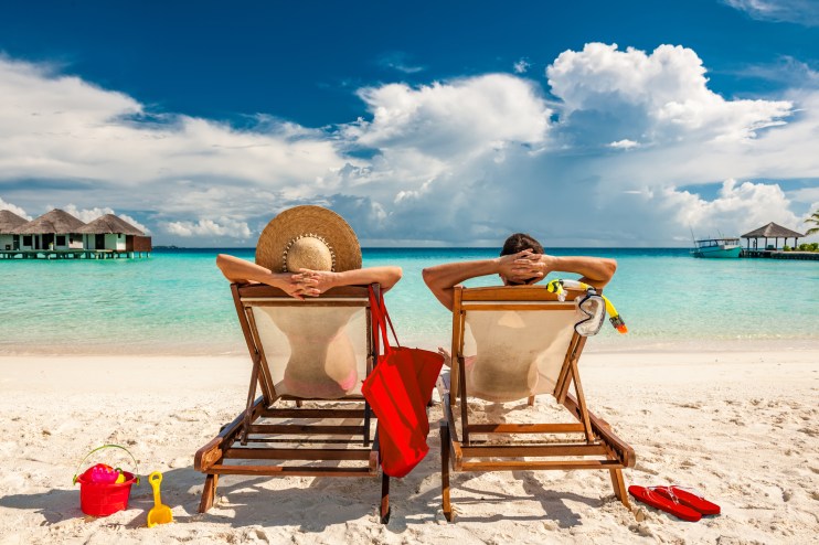 Sunny winter beach scene with golden sand, clear blue sky, and gentle waves, ideal for a relaxing holiday getaway.