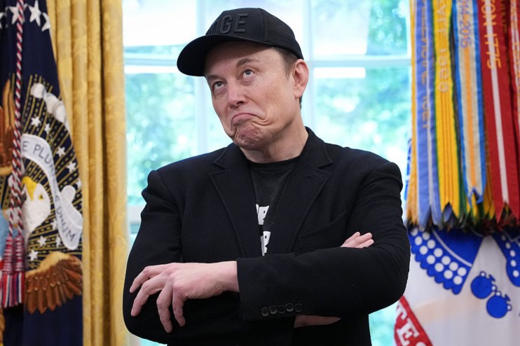 Elon Musk speaking at a tech conference, wearing a suit, with a futuristic backdrop highlighting space exploration themes
