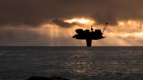 North Sea oil terminal with storage tanks and docking facilities under a clear sky, highlighting energy infrastructure.