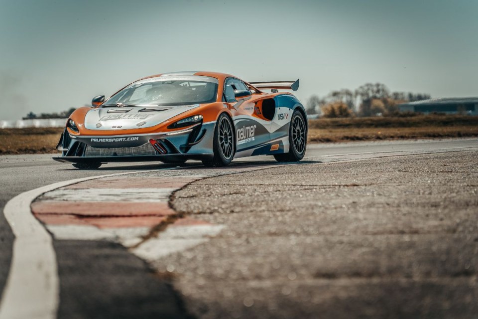 McLaren F1 car on the racetrack during a competitive event, showcasing aerodynamic design and vibrant team colors