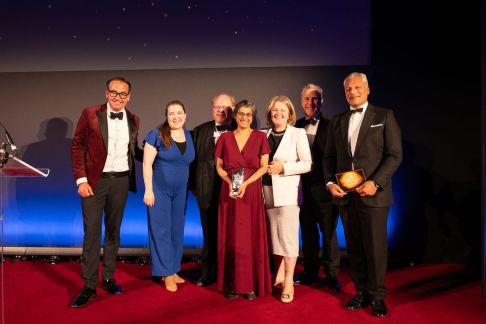 Hogan Lovells team celebrates City PM Awards victory, showcasing joy and achievement in a prestigious business event setting