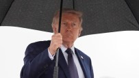 Breaking news conference podium with microphone, focused on speakers notes and event backdrop, set for journalist updates