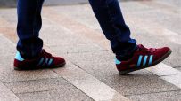 Adidas logo displayed prominently on a sleek storefront, representing the brands iconic presence in the sportswear industry.