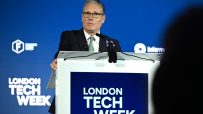 Keir Starmer at tech event discussing innovation and policy, surrounded by tech leaders and digital displays