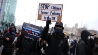 Protesters hold signs saying STOP Chinese Secret Policing in the UK and Safeguard National Security