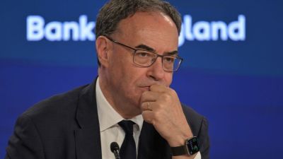 Andrew Bailey, Governor of the Bank of England, in a suit and tie, looking thoughtful during a press conference.