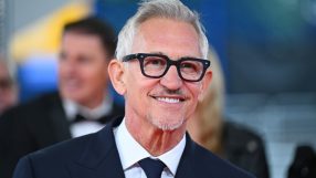 Gary Lineker in a suit and tie, smiling with glasses and a goatee, against a blurred background.