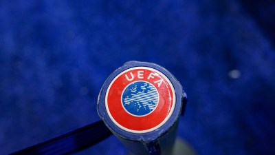 Close-up of a blue and red UEFA logo on a sports equipment handle against a blurred blue background