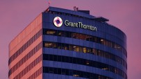 Grant Thornton building exterior with illuminated logo and name against a dramatic pink and purple sky at dusk.