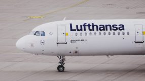 Lufthansa aircraft on tarmac with logo visible, showcasing airlines fleet under clear sky in a business news context
