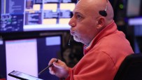 Stock trader with headset and tablet monitors market data, reflecting Nasdaq, NYSE correction concerns.