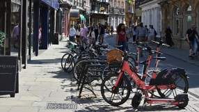 Voi electric scooters lined up on a city street, highlighting urban mobility solutions and eco-friendly transportation opt...