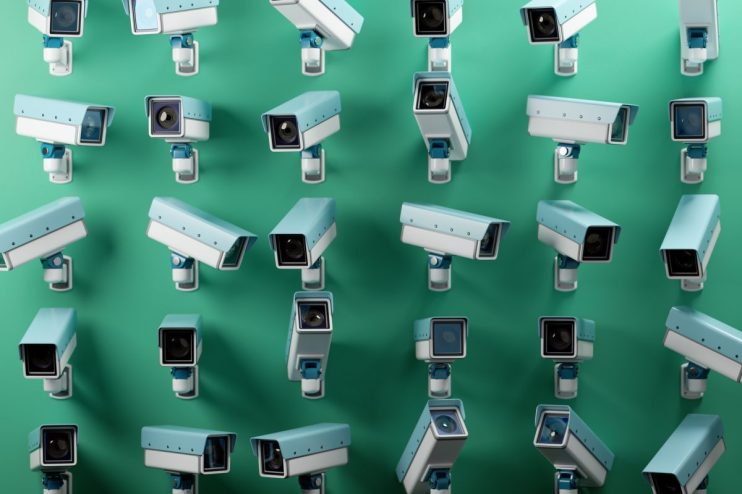Multiple CCTV security cameras in light blue and white against a green background, emphasizing surveillance and monitoring.