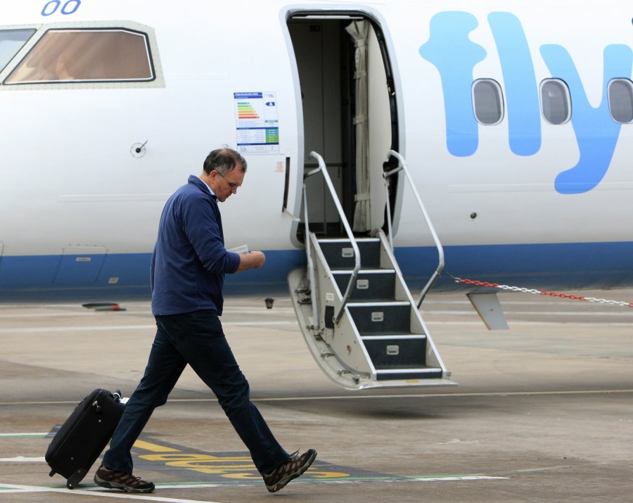 A passenger checks his ticket as he prep